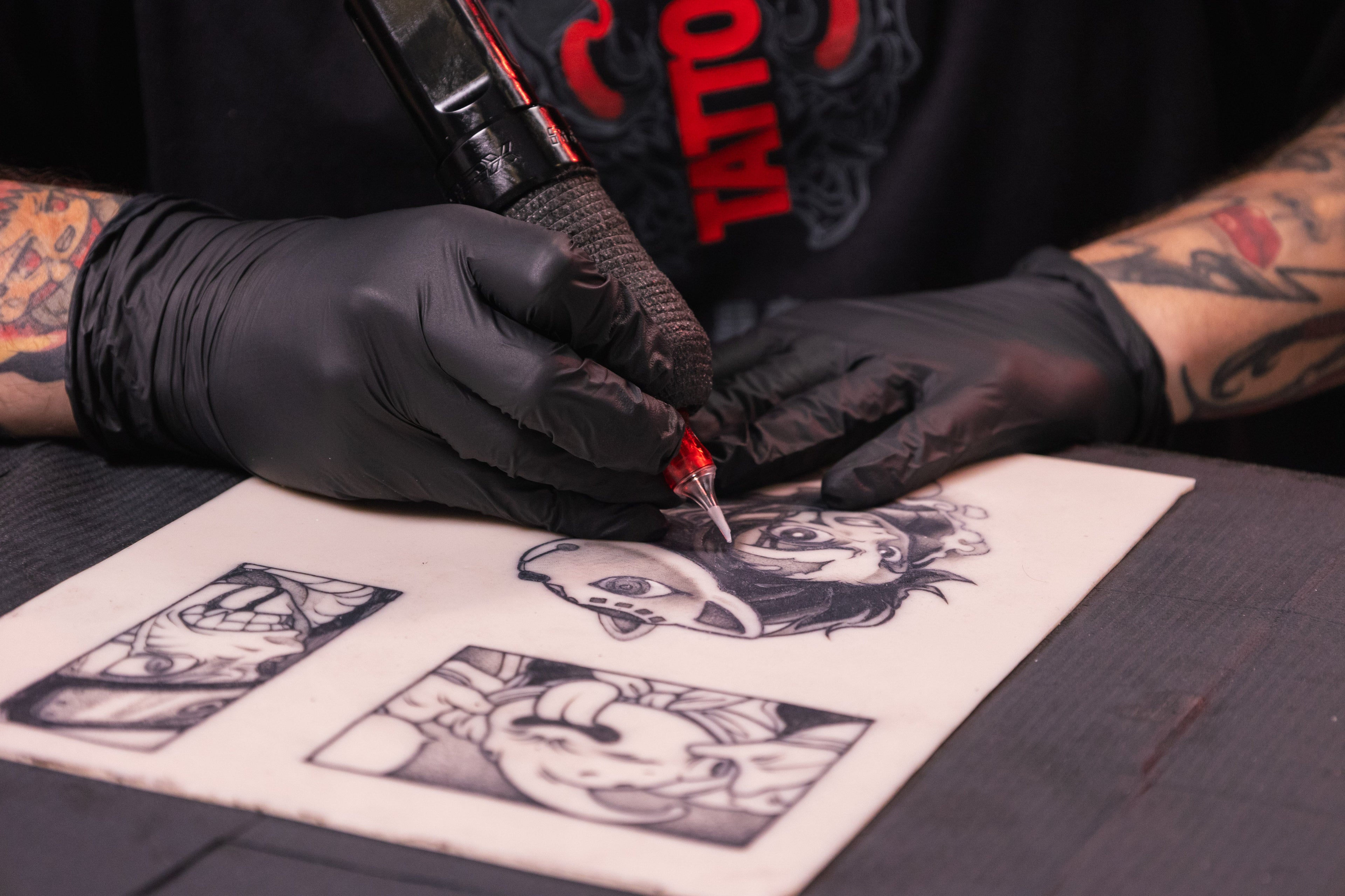 Tatuador tatuando sobre piel sintética